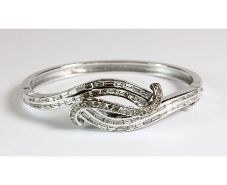 A superb 18ct white gold bangle set with over 6ct of baguette and brilliant cut diamonds. Est. £2,000 - 3,000