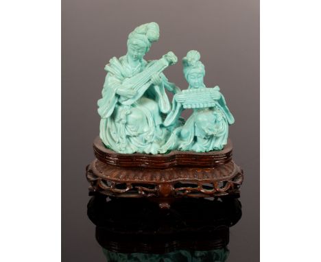 A 20th Century carved turquoise statue depicting two female musicians playing traditional instruments, on a wooden stand, 8.5