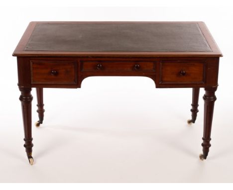 A late Victorian mahogany writing table with inset writing surface above three drawers, on fluted legs with ceramic castors, 