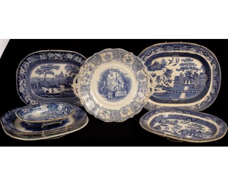 Six English blue and white meat plates, including a tree and well example printed Chinese views, a tureen stand and a pie dis