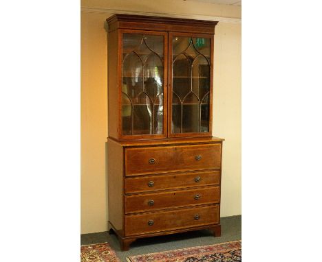 A Regency mahogany secretaire bookcase, enclosed by a pair of glazed shaped bar doors, with fitted secretaire and three furth