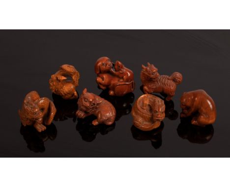 Seven Japanese carved boxwood netsuke, 20th Century, depicting dragons, foo dogs etc./Provenance: The Estate of Anthony J Bee