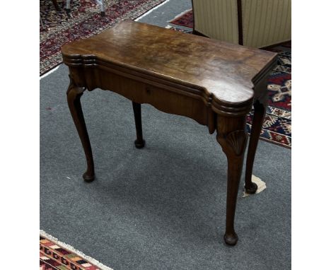 A George II mahogany tea/card table, the rectangular top with lobed front corners, the twin-hinged leaves enclosing a tea tab