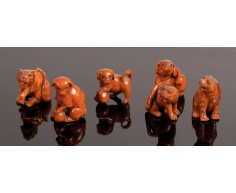 Six Japanese carved boxwood netsuke, 20th Century, depicting tigers and dogs/Provenance: The Estate of Anthony J Beeson CONDI