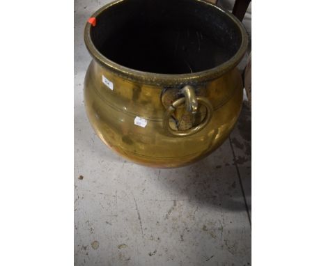 A traditional large brass cauldron, having animalistic/bird ring handles, Eastern design