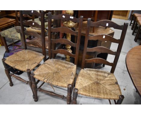 Three 19th Century oak ladder back chairs having rush seats