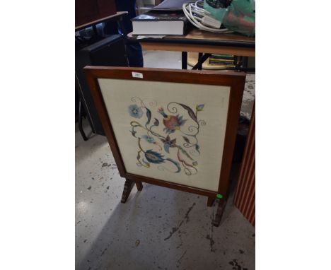 An early mahogany folding firescreen/tea trolley, having embroidered panel