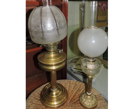 A late 19th century oil lamp, with a clear glass reservoir and opaque globe shade, on a fluted column and circular base, H. 6