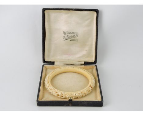 An early 20th Century Cantonese ivory bangle carved with a band of flowerheads.