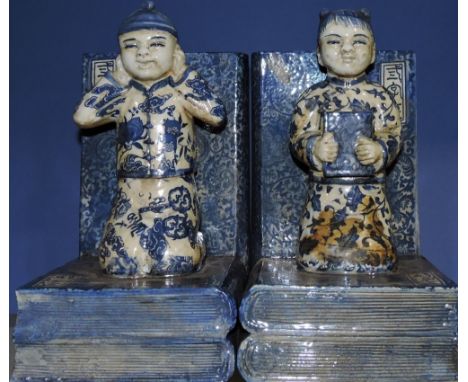 A pair of blue and white ceramic bookends, modelled as a young boy and girl, H. 20cm.