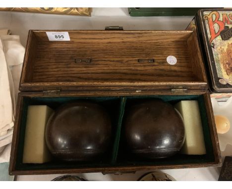 A PAIR OF VINTAGE BOWLING BOWLS IN OAK CARRYING CASE 