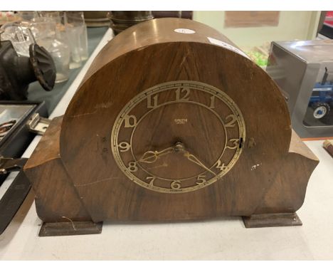 A WOODEN MANTEL CLOCK WITH BRASS DETAIL 