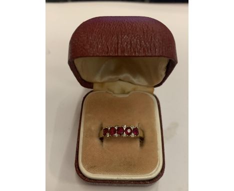 A 9 CARAT GOLD RING WITH FIVE ON LINE RED STONES AND EIGHT CLEAR STONES 