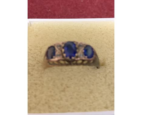 A 9 CARAT YELLOW GOLD RING WITH THREE IN LINE BLUE STONES GROSS WEIGHT APPROXIMATELY 2.1 GRAMS 