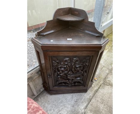 A LATE VICTORIAN OAK CORNER CUPBOARD WITH HEAVILY CARVED SINGLE DOOR AND SHAPED INTERIOR SHELF, 26" WIDE 