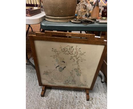 AN OAK FRAMED NEEDLE WORK FIRESCREEN 