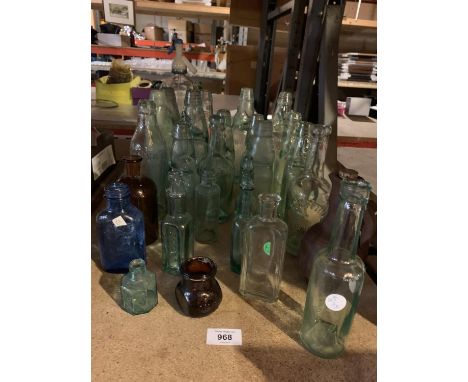 A LARGE ASSORTMENT OF VINTAGE GLASS BOTTLES TO ALSO INCLUDE A GLASS SODA SYPHON 