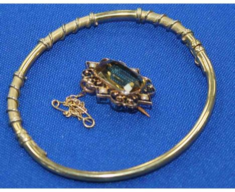 NINE CARAT GOLD CITRINE AND SEED PEARL BROOCH AND A NINE CARAT GOLD BANGLE
the brooch with a scrolling border, 10.5g gross