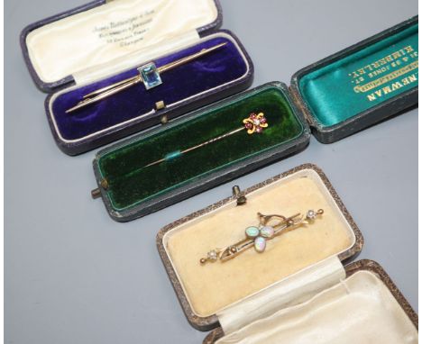 An Edwardian ruby &amp; diamond set stick pin, a yellow metal and white opal bar brooch and a 9ct gold and blue stone set bar