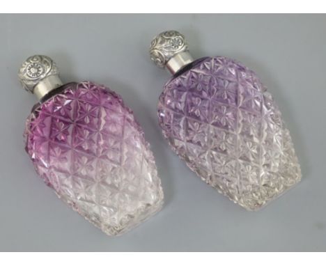 A pair of late Victorian silver lidded amethyst tinted cut glass scent flasks, of baluster form, C.C. May &amp; Sons, Birming