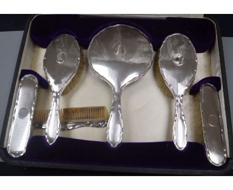 A cased George V engine turned silver six piece dressing table set.