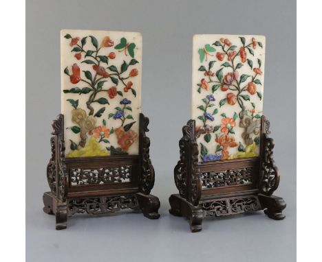 A pair of Chinese hardstone and coral table screens with hongmu stands, early 20th century, the rectangular plaques applied w