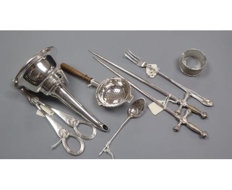 A George III silver mote spoon, a napkin ring, a tea strainer, pair of plated 'sword' skewers, a wine funnel and a pair of gr