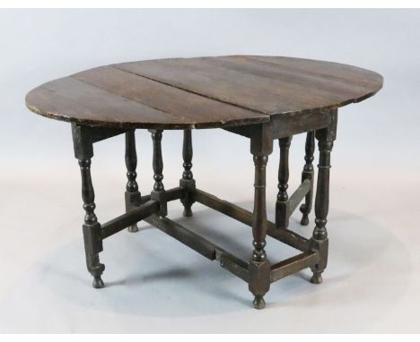 An early 18th century oak oval topped gateleg dining table, with turned and squared underframe, 4ft 4in. x 3ft 3in. H. 2ft 3i