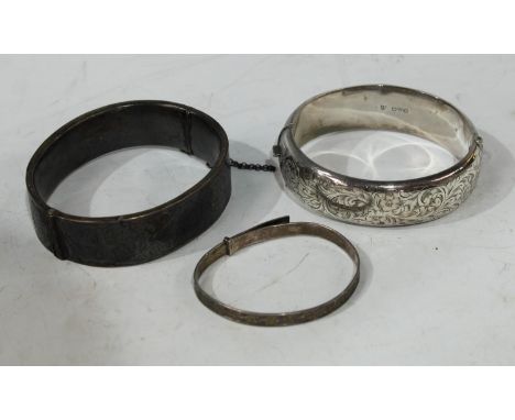 A hallmarked silver bangle; another, similar; a sterling silver bangle (3) 