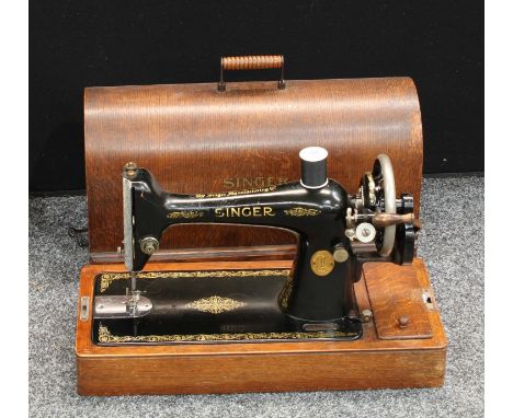 A manual Singer sewing machine, arched oak carry case with key 