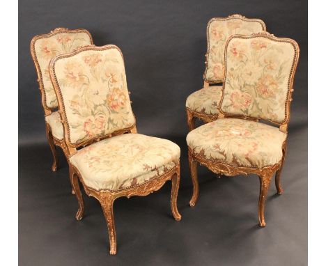 A set of four Louis XV Revival giltwood and gesso drawing room chairs, each shaped rectangular back carved with scrolling aca