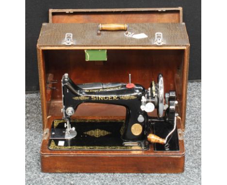 A Singer sewing machine, manual and fitted to use with electricity, carry case 