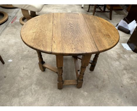 A MINIATURE OVAL OAK GATE LEG OCCASIONAL TABLE ON TURNED SUPPORTS - 26" X 20.5" OPENED 