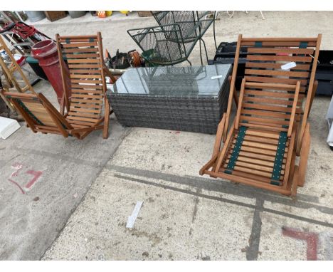 TWO FOLDING TEAK SUN LOUNGERS AND A RATTAN COFFEE TABLE 