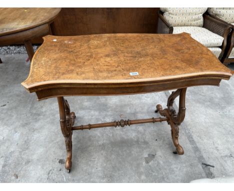 A VICTORIAN WALNUT FOLD OVER GAMES TABLE WITH LYRE SUPPORTS AND TURNED STRETCHER ON BRASS CASTERS 