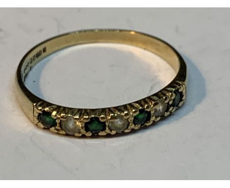 A 9 CARAT GOLD RING WITH FOUR EMERALDS AND THREE CUBIC ZIRCONIAS IN A LINE SIZE Q/R 