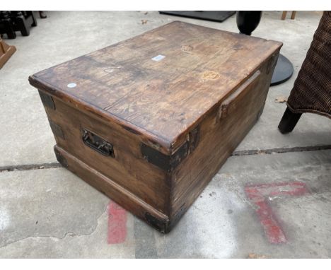 A SMALL PINE TRUNK WITH METAL HANDLES AND EDGES 