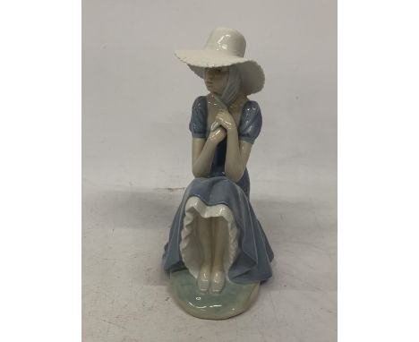 A NAO FIGURE OF A GIRL HOLDING HER BONNET STRAPS 