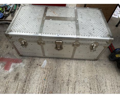 A LARGE ALUMINIUM COVERED TRAVEL TRUNK 