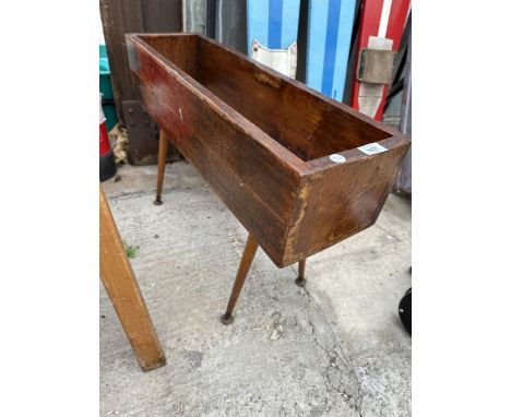 A WOODEN TROUGH PLANTER ON RETRO LEGS 