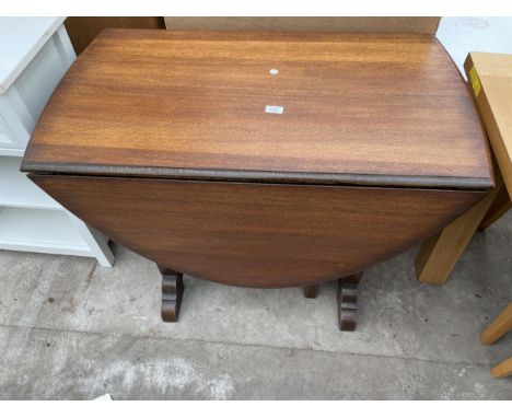 A MID 20TH CENTURY OAK DROP LEAF DINING TABLE WITH CARVED PANEL ENDS 