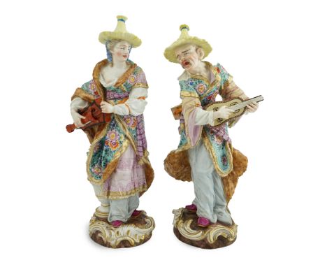 A pair of Meissen Malabar Musicians, 19th century, after the models by F.E. Meyer, both wearing straw hats, floral fur-lined 