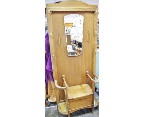 A 1930's/40's oak hall stand, shaped mirror, seat with hinged cover flanked by stick sands to base