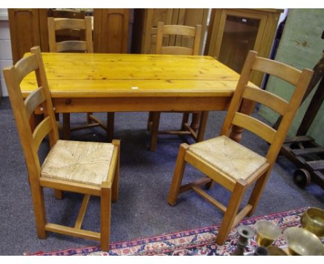 A modern pine kitchen table 78cm high x 167cm long x 89cm wide; four ladder back chairs with raffia seats