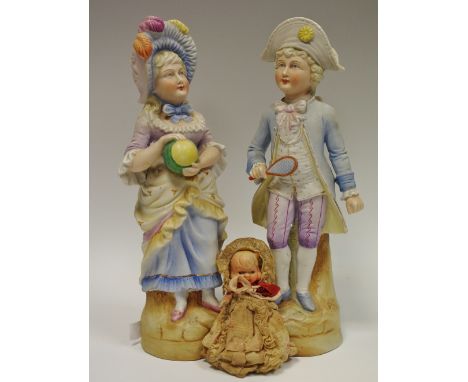 A pair of late 19th century German porcelain figures playing tennis; a small composite doll (3)