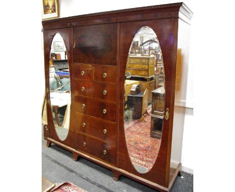 A Walter Carter (Harrod's Ltd) Manchester flame mahogany compactum, outswept cornice with diamond banding, single door cupboa