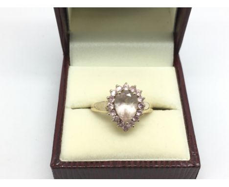 A 9ct gold ring set with a central heart shaped pink morganite surrounded by small pink stones, approx 3.2g and approx size L