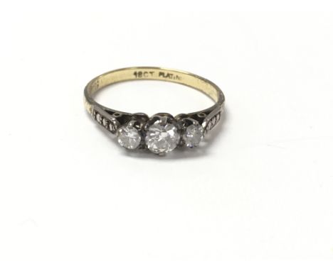 An 18 carat gold and platinum ring set with three cushion cut diamonds. Measuring approximately ring size n.