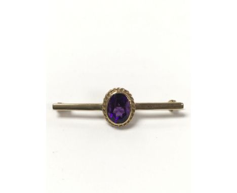 A 9 carat gold bar brooch set with an amethyst stone, weighing approximately 1.8g.