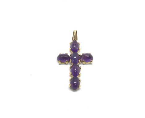 A 9ct gold cross set with cabochon amethyst
